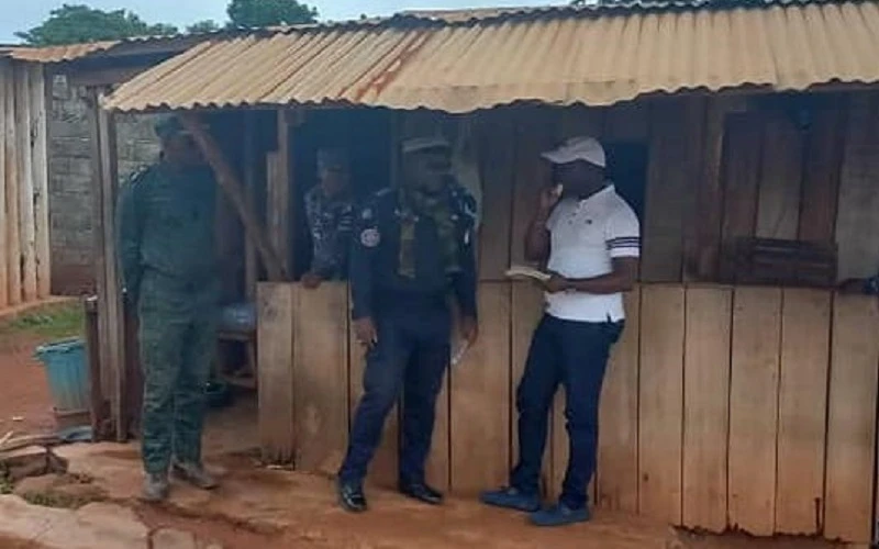 Le Commissaire du gouvernement Ange Kessi (en blanc) échange avec des agents à un corridor